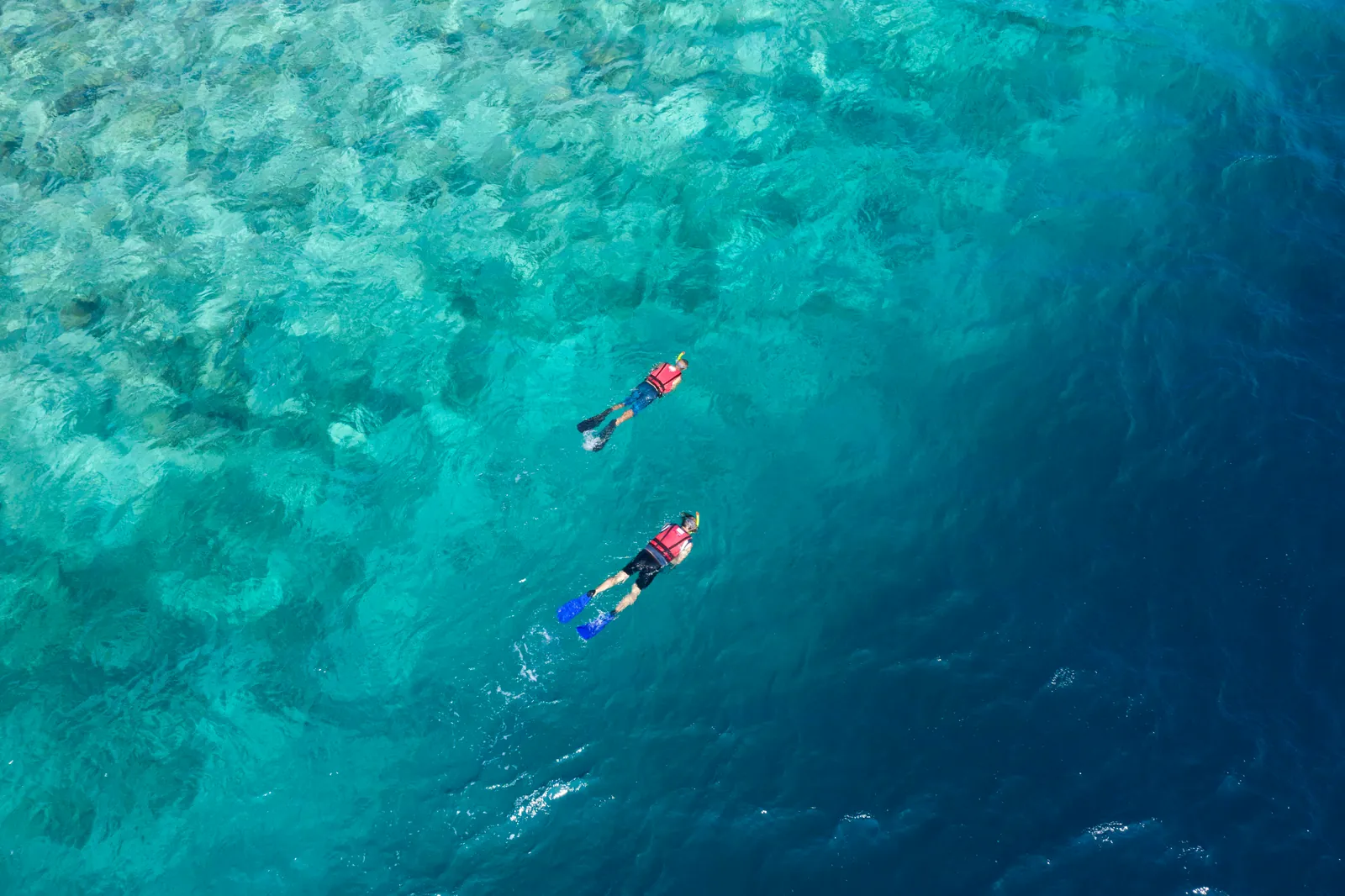 Hosť na paddleboarde v lagúne pri ostrove